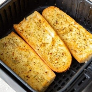 3 halves of garlic bread inside the air fryer cooked