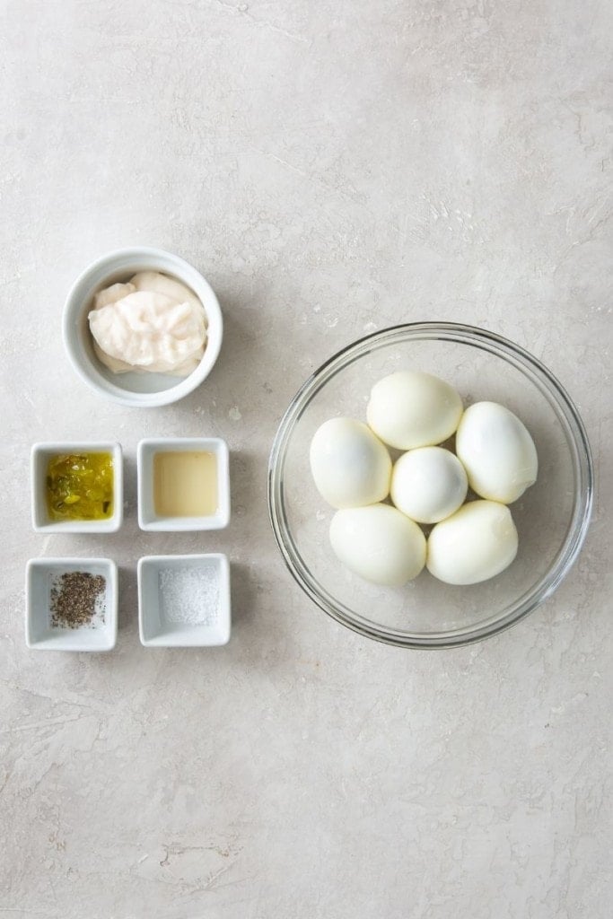 Ingredients needed to make deviled eggs inside different bowls