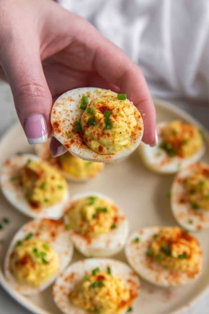 Hand holding a deviled egg