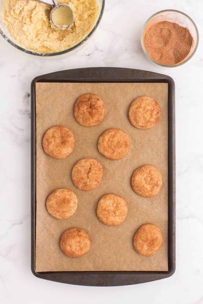Baked snickerdoodle cookies without cream of tartar on a baking sheet lined with brown parchment paper