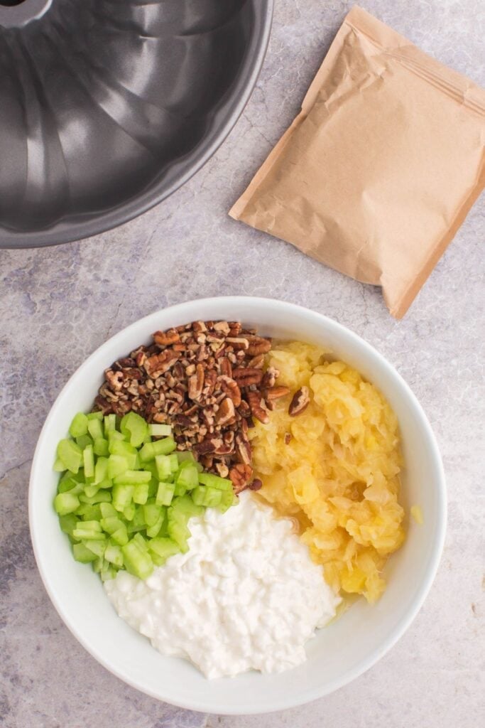 Ingredients needed to make lime jello salad: canned pineapple and the juice, water, lime jello mix, cottage cheese, celery, pecans.