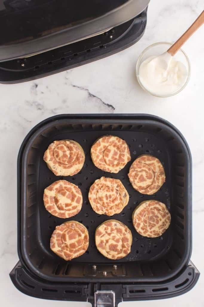 Raw Pillsbury Cinnamon Rolls in air fryer basket