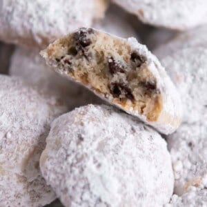 Closeup of snowball cookie bitten in half surrounded by other snowball cookies