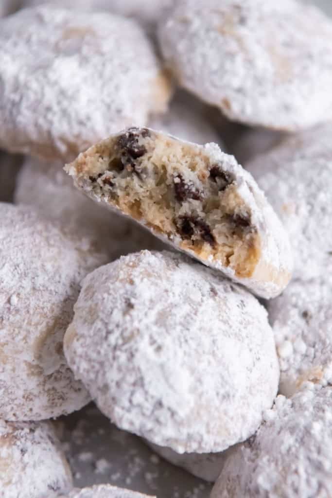 Closeup of snowball cookie bitten in half surrounded by other snowball cookies