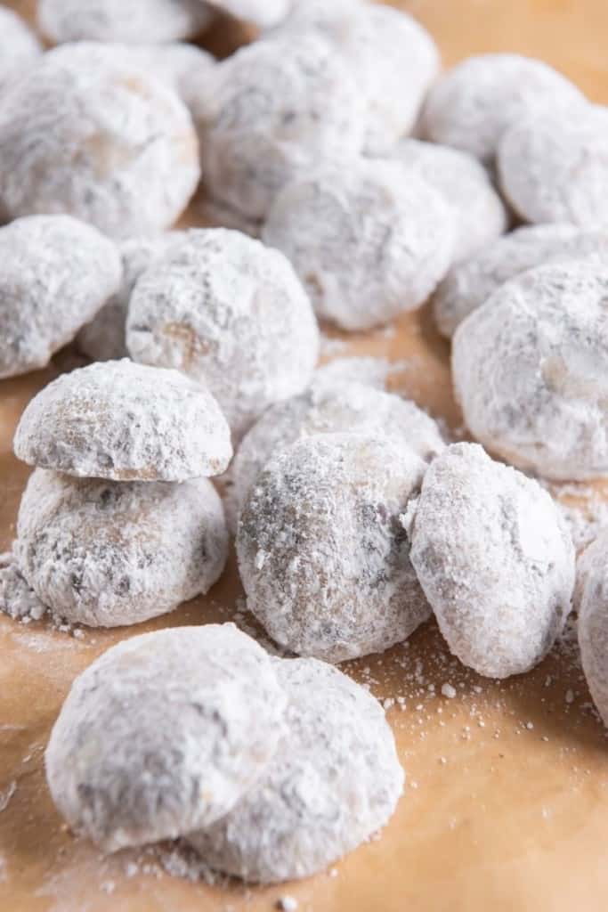 Snowball cookies with chocolate chips on brown parchment paper