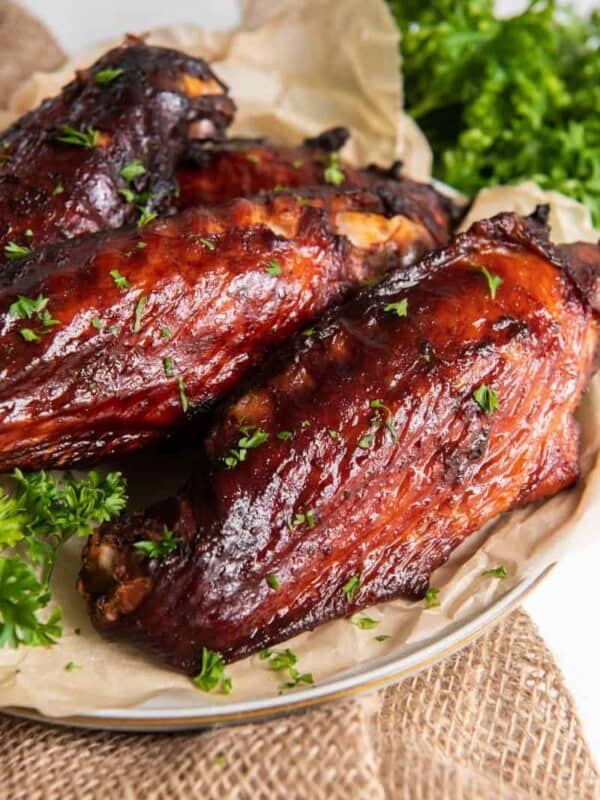 Air Fryer Turkey Wings served on a white plate with parchment paper underneath them