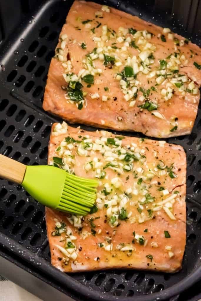 Air Fryer Salmon being basted by a silicone baster as an air fryer accessory
