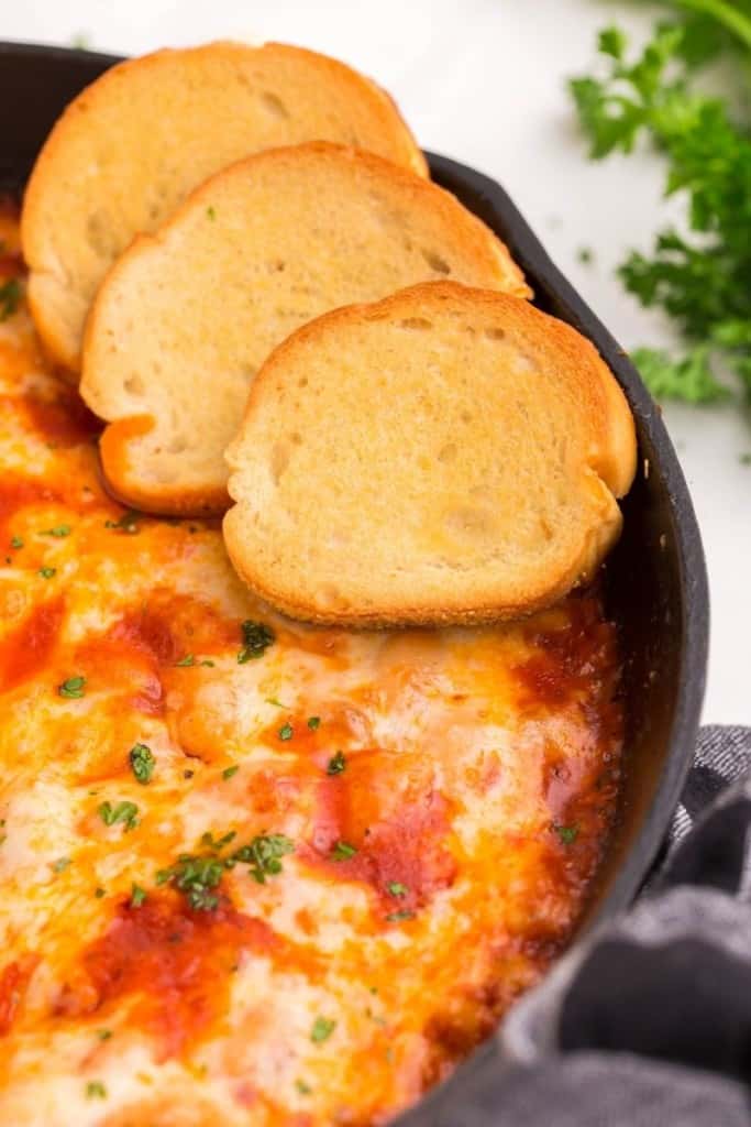 bread slices in a dish of cheesy white bean tomato bake