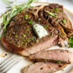 air fryer t bone steak on a white plate, cut into.