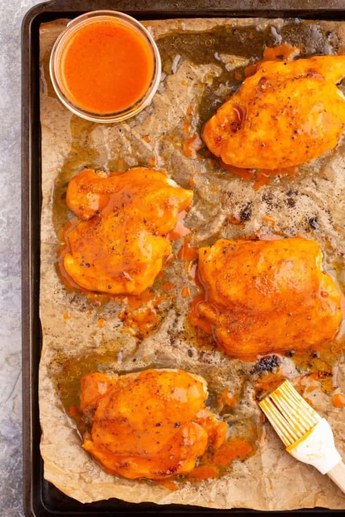 baste buffalo sauce over chicken thighs