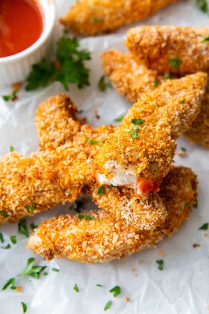 Several air fryer buffalo chicken tenders with one bitten into