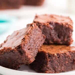 Three fudgy brownies without cocoa powder on plate