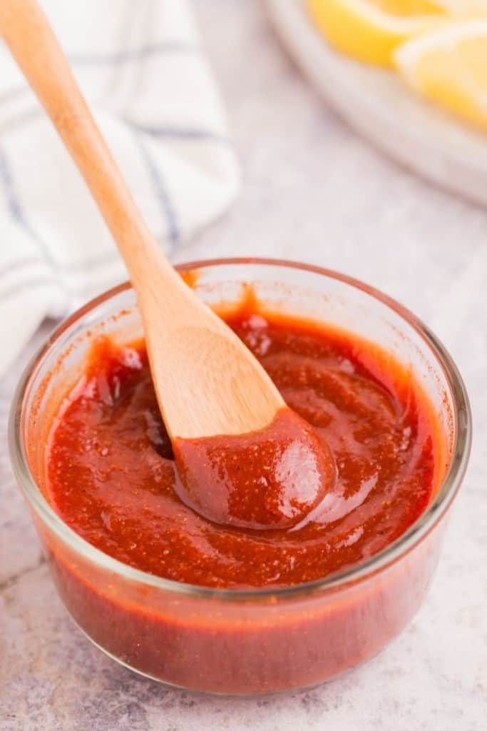 small bowl with wooden spoon swirled in cocktail sauce