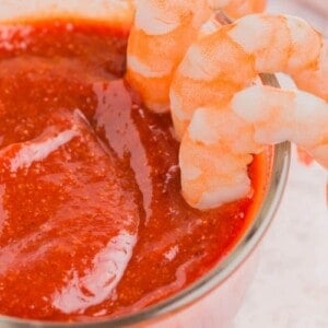 Cocktail sauce without horseradish in dish with shrimp being dipped in