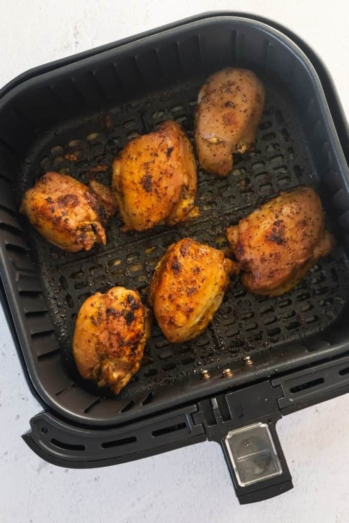 Frozen chicken thighs with lemon pepper seasoning in air fryer