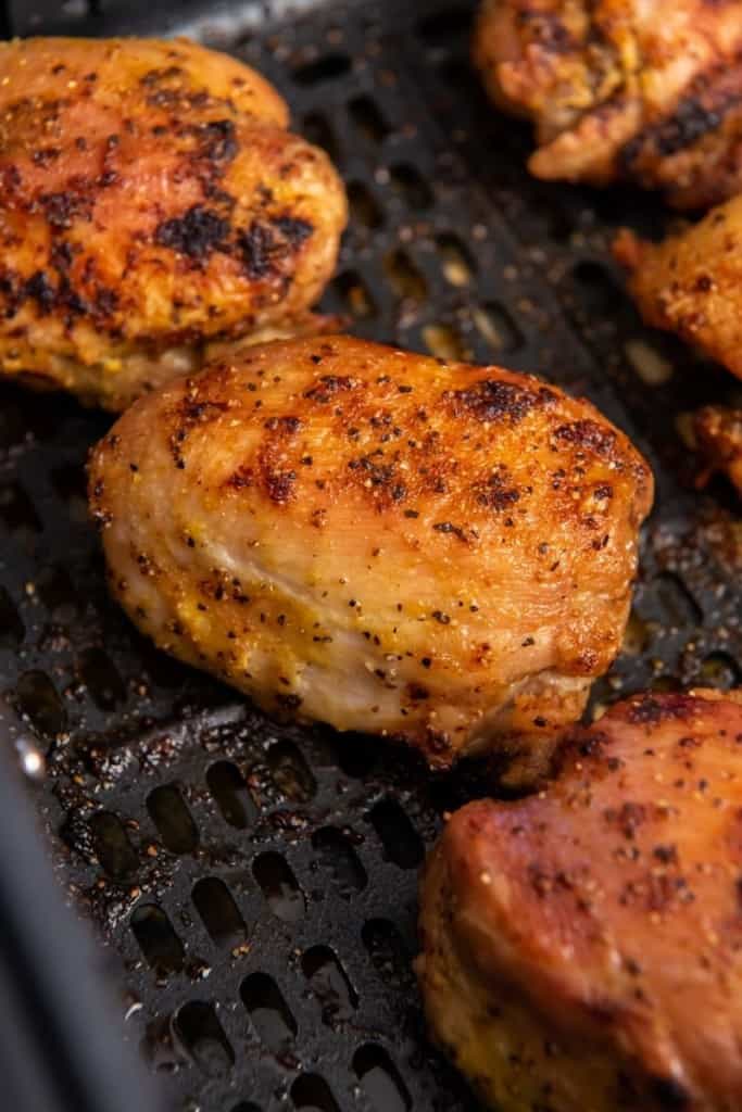 zoom in on cooked and seasoned chicken thigh in air fryer