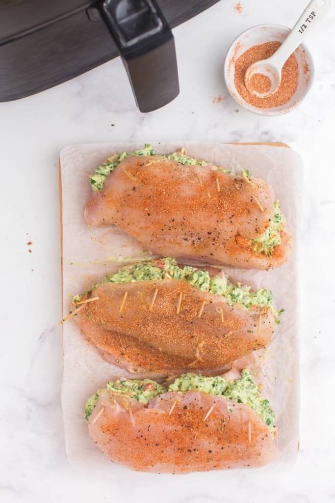 fold chicken breasts over with seasonings and spinach mixture inside