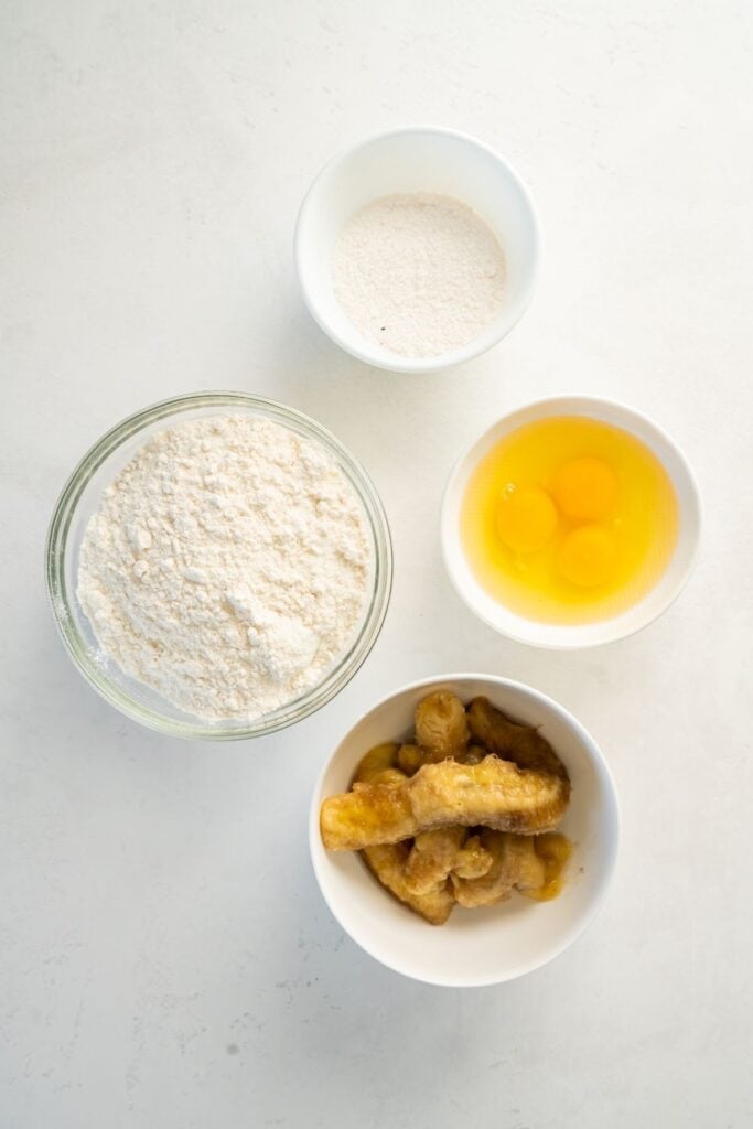Ingredients needed to make cake mix banana bread: vanilla pudding, yellow cake mix, bananas, and eggs.