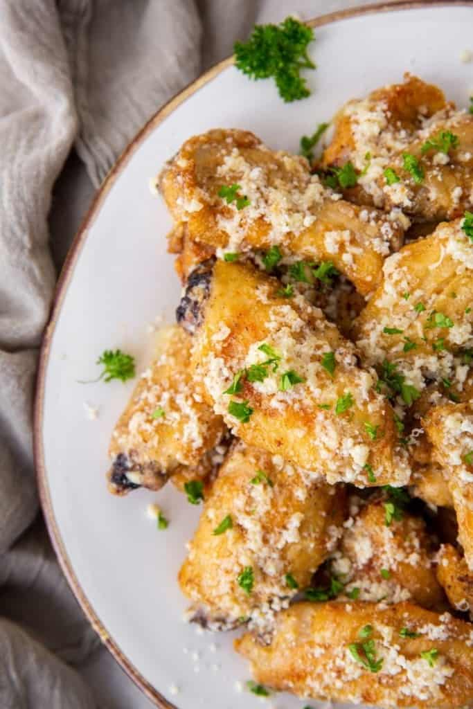 garlic parmesan wings piled on plate