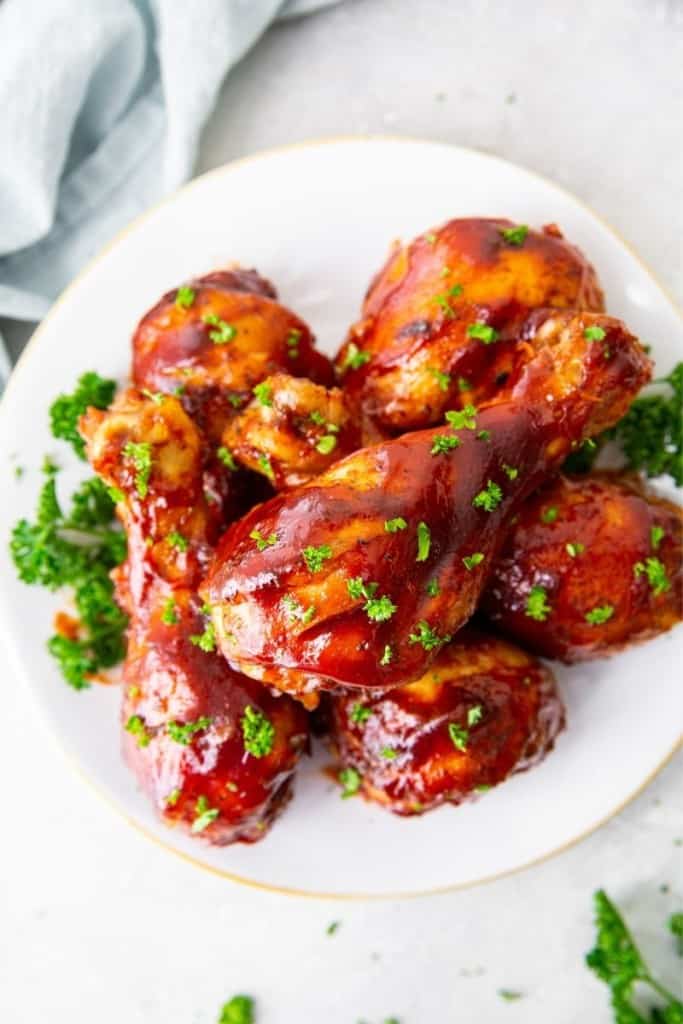 white plate with several instant pot chicken drumsticks on it
