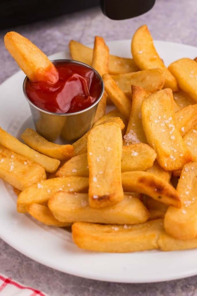 Golden and crispy air fryer steak fries on plate with dipping sauce