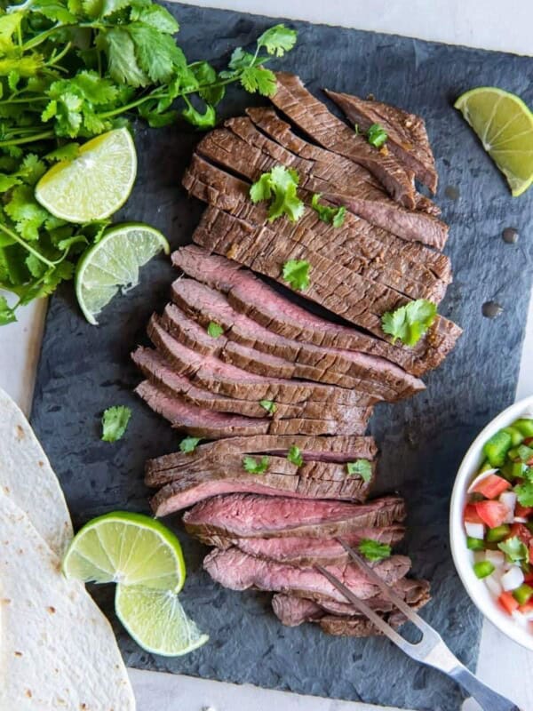 sliced air fryer skirt steak with lime wedges