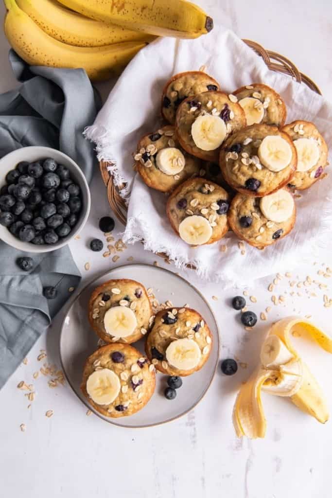 banana blueberry oatmeal muffins on plate with bowl of blueberries on side