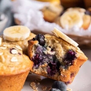 Banana blueberry oatmeal muffin on plate with bite taken out