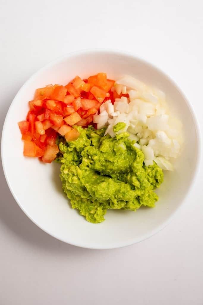 mix mashed avocado, tomato, and onion for avocado dip