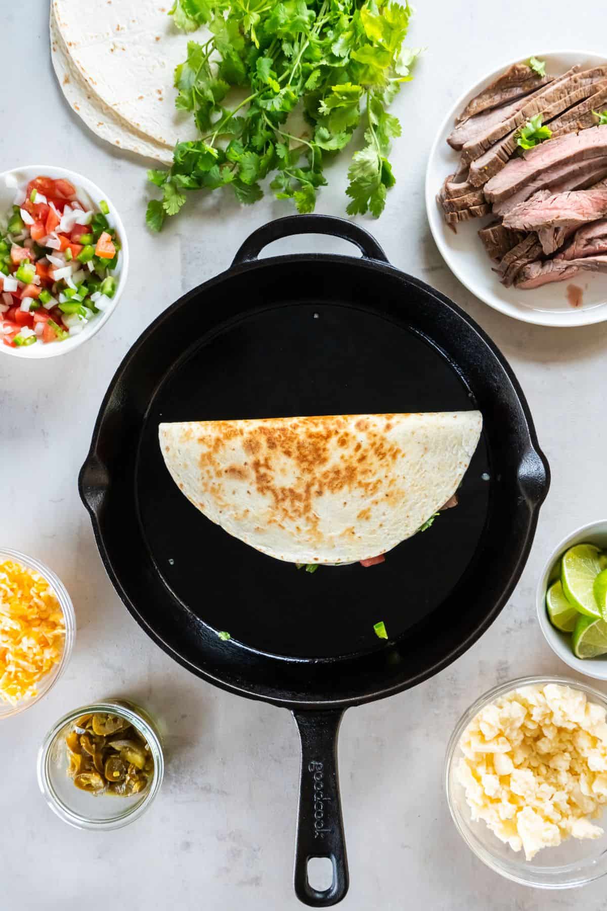 The carne asada quesadilla tortilla folded over to show the golden brown on the outside.