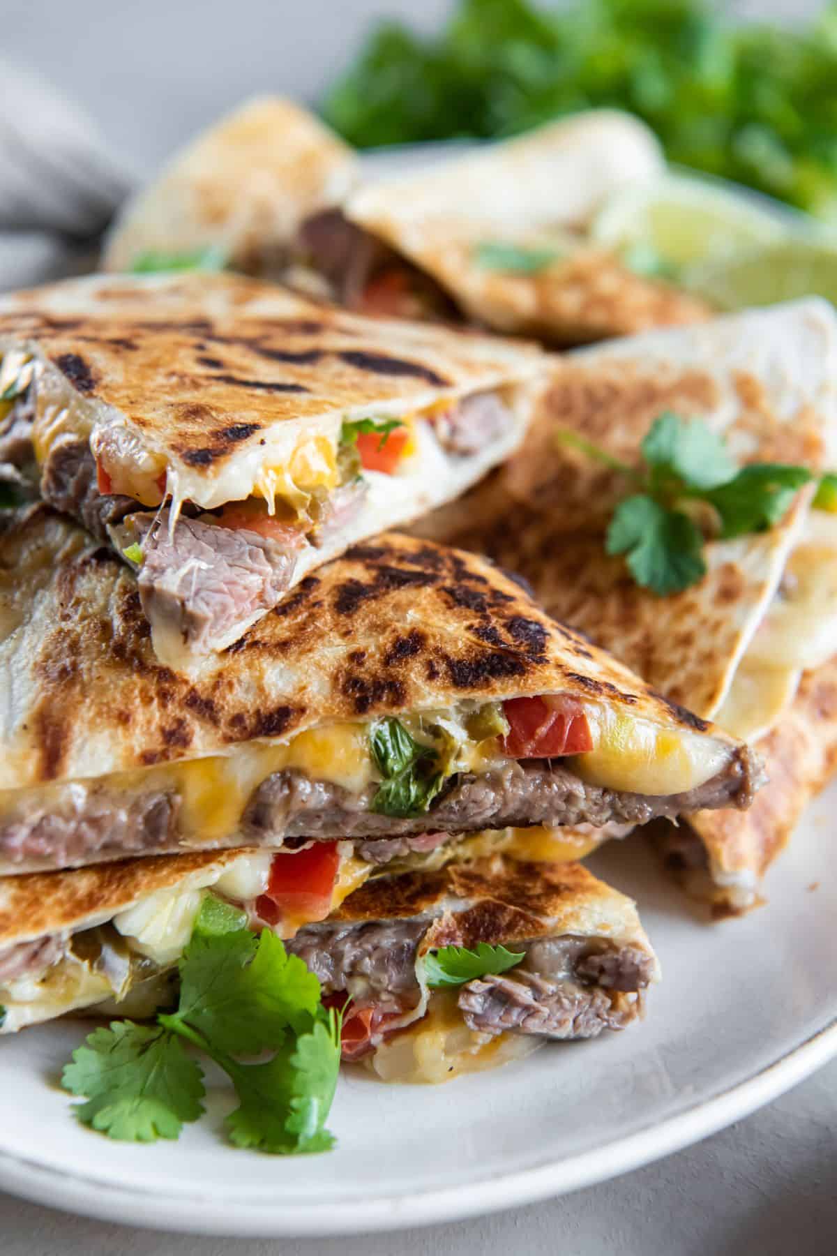 Carne asada quesadillas slices stacked on top of each other.