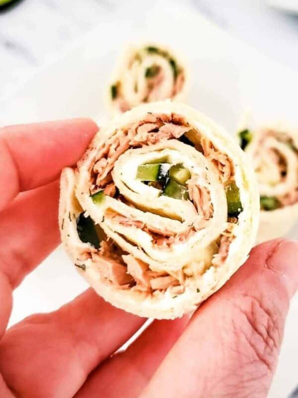 Slice of tuna pinwheel held in a hand