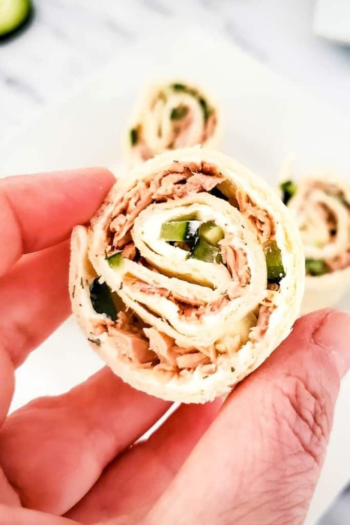 Slice of tuna pinwheel held in a hand