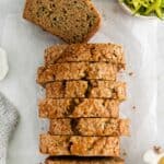 Zucchini bread with applesauce sliced on a counter with a piece lying flat to see the inside.