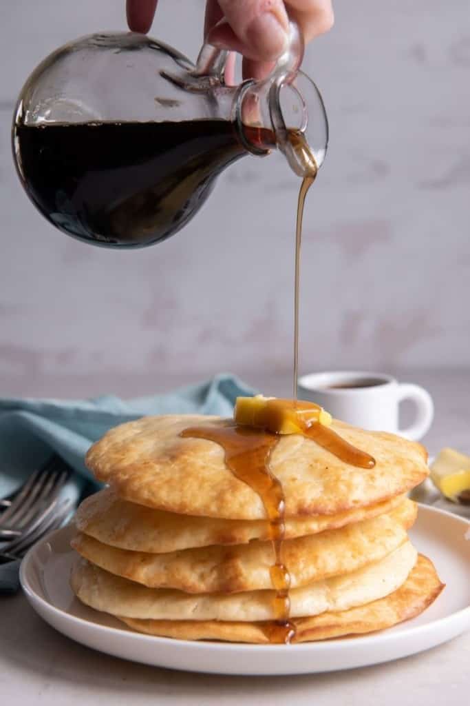 syrup pouring over stack of air fryer pancakes