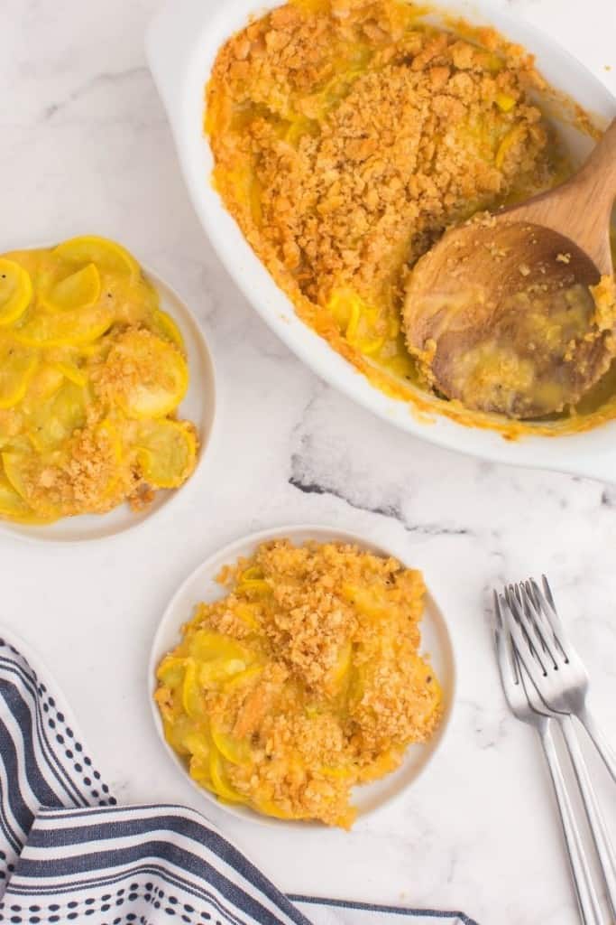 squash casserole dished onto plates next to casserole dish