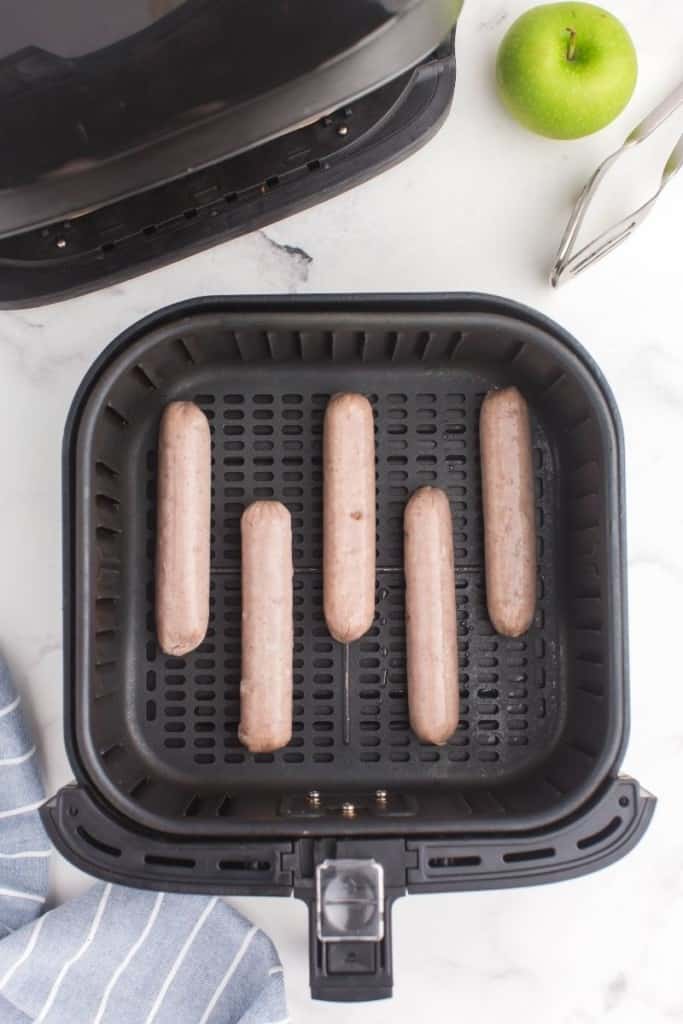 place chicken sausages in air fryer with space between each one
