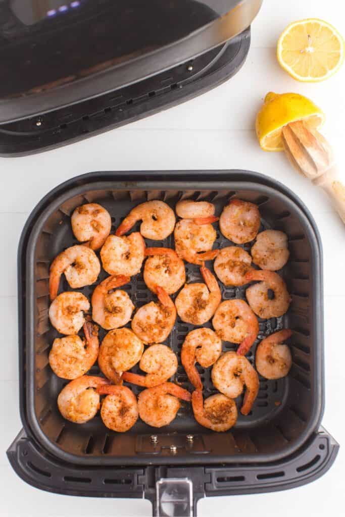 frozen shrimp in an air fryer basket before being cooked.