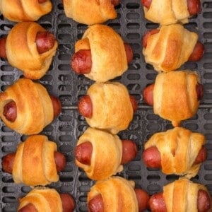 Close up of pigs in a blanket in the air fryer basket.