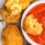 dipping mac and cheese bite into sauce