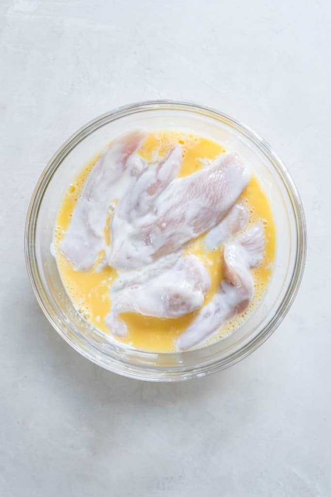 dipping chicken tenders in egg mixture
