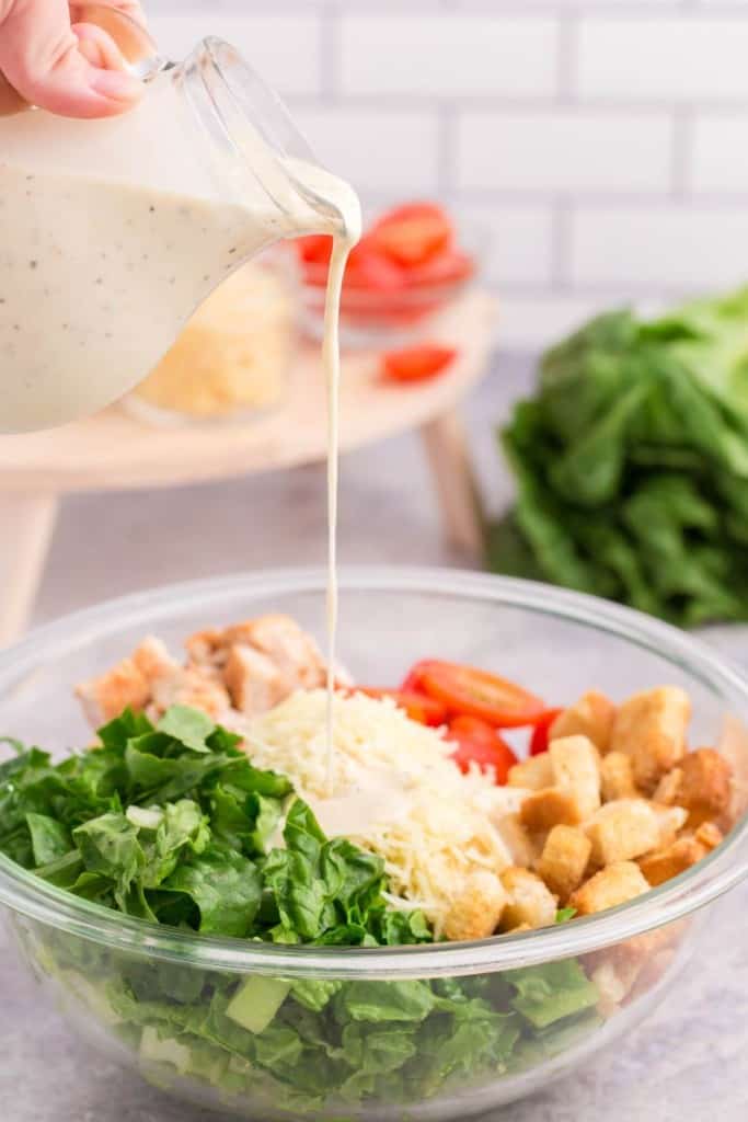 pouring dressing on chicken salad