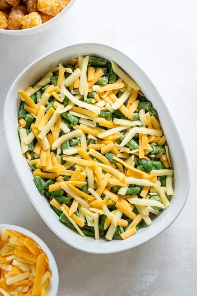 Green beans and cheese placed on top of the casserole.