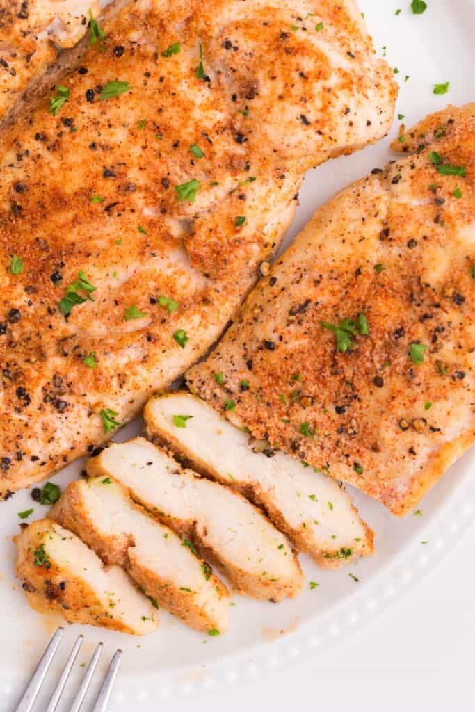 Close up of grilled chicken cooked in an air fryer with one slice cut into slices until halfway through.