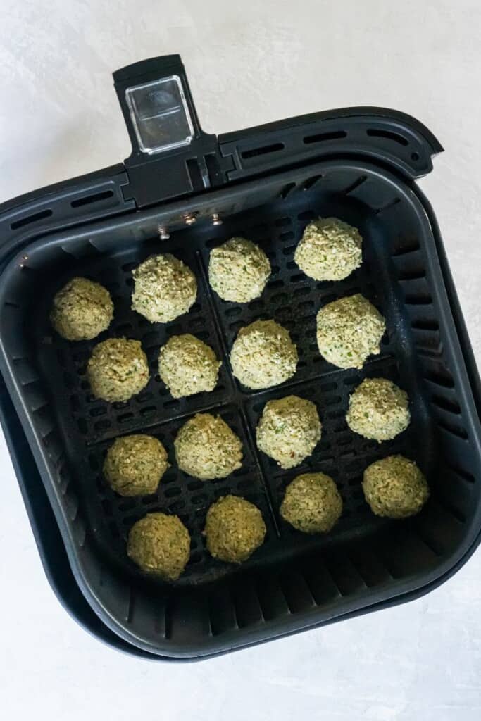 adding falafel to air fryer basket