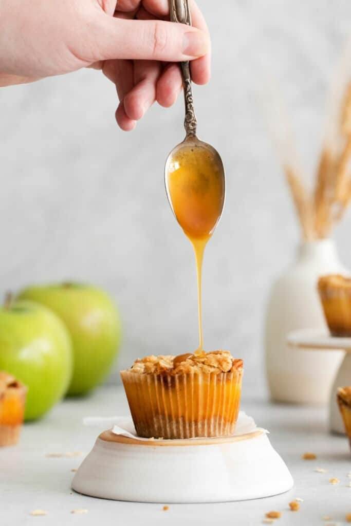 drizzling caramel on apple crisp mini cheesecake