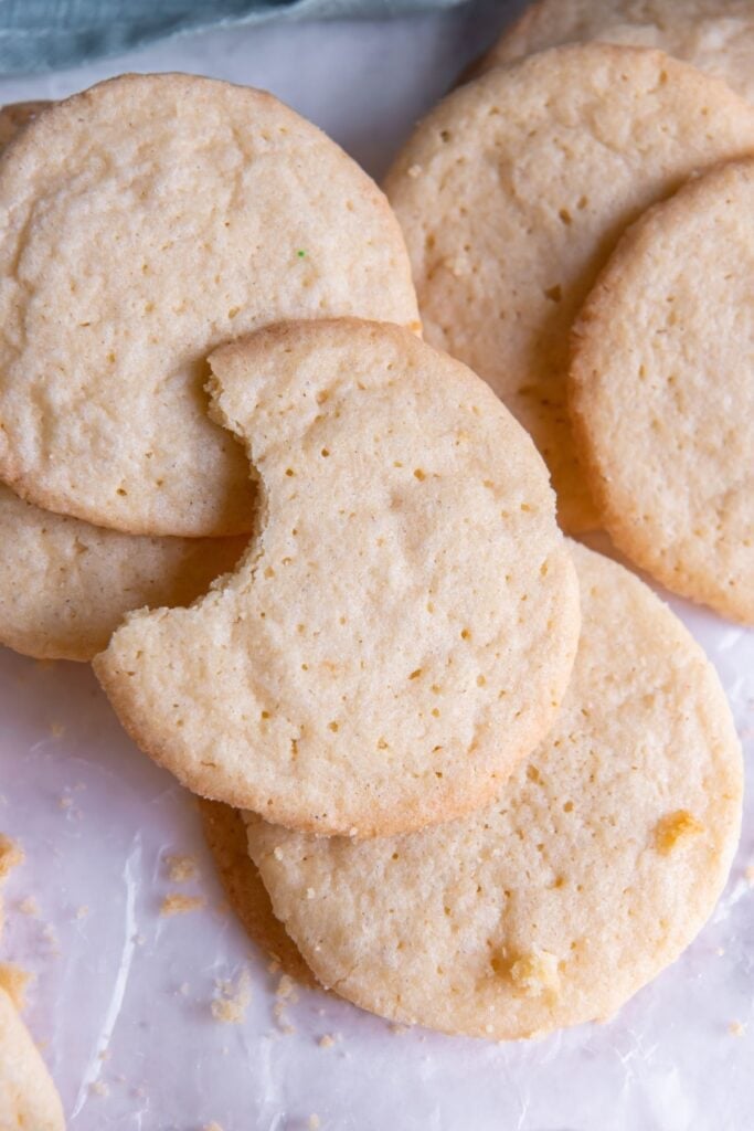 Sugar cookie recipe without baking soda on the counter with a bite taken out of one of them.