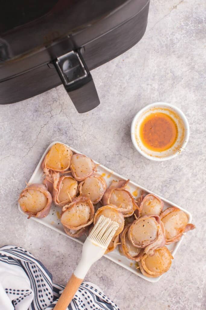 brushing sauce onto scallops
