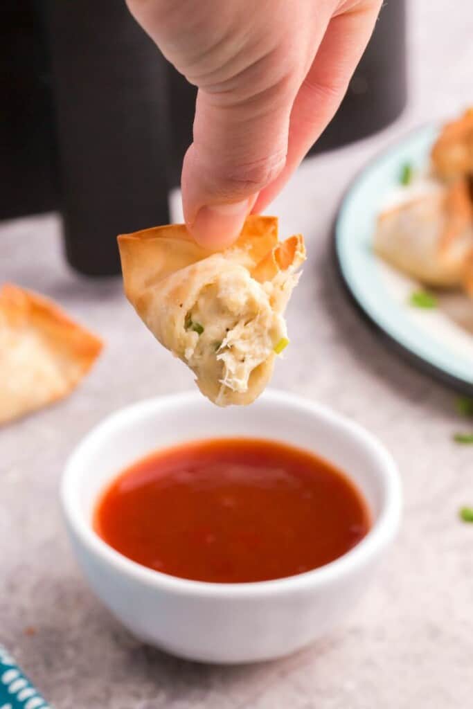 dipping crab rangoon in sauce