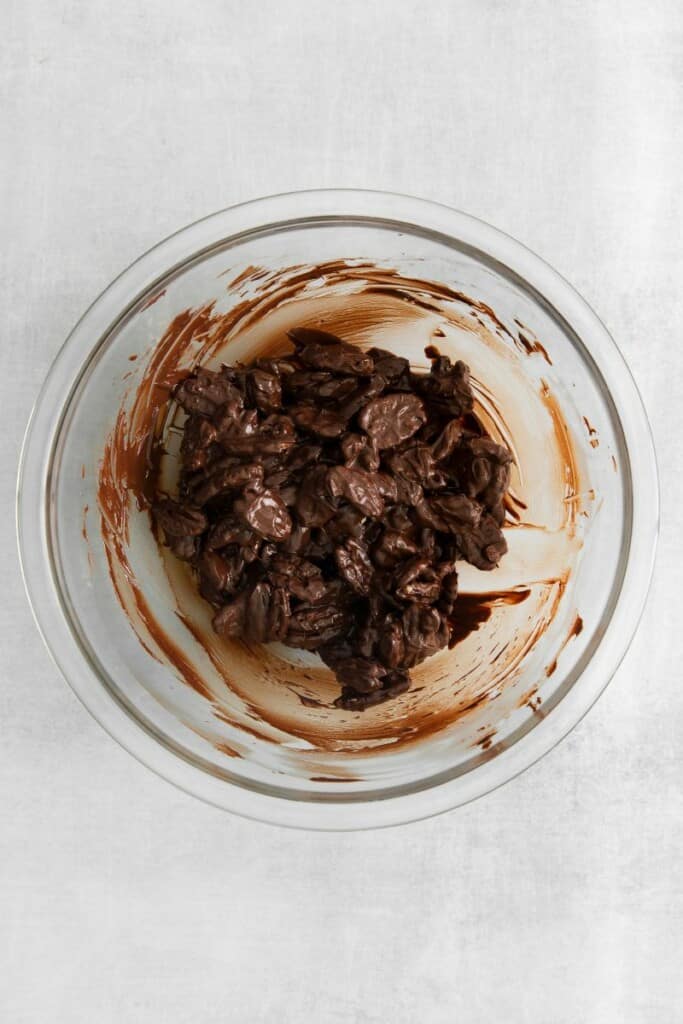 chocolate covered pecans mixed in a clear bowl